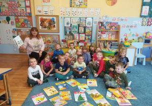 Zdjęcie grupowe - dzieci i nauczycielka wśród książek i czasopism o misiach.
